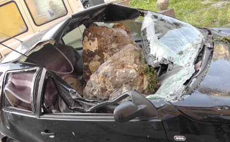 Woman cheats death as rock destroys car