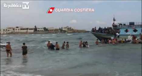Beachgoers make human chain to save migrants