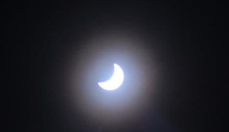 Spaniards get clouded view of solar eclipse
