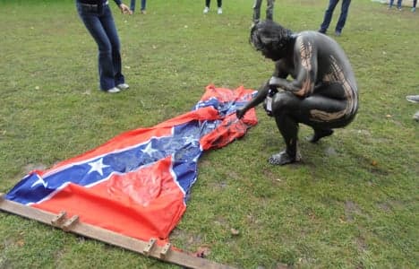 Danish artist in blackface burns Confederate flag