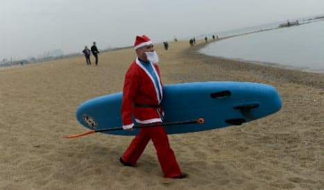 Surf's up: Dozens of Santas take to the waves in Barcelona