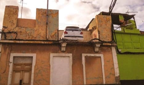 Police baffled by car parked on top of house in Spain