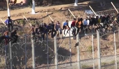 Dozens stuck on border fence for hours in bid to enter Spain