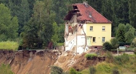 Landslide tips house into lake