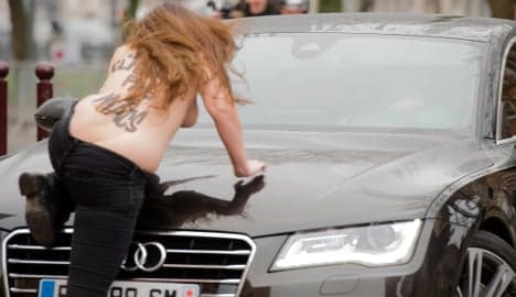 Topless protesters jump on Strauss-Kahn's car