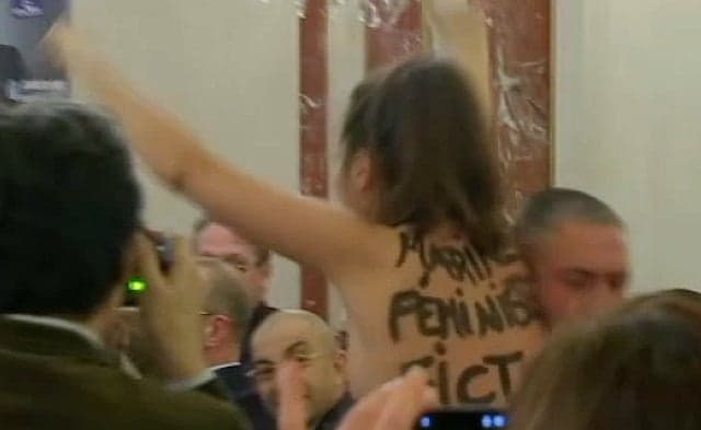 Topless woman disrupts Marine Le Pen speech and calls her a 'pretend feminist'