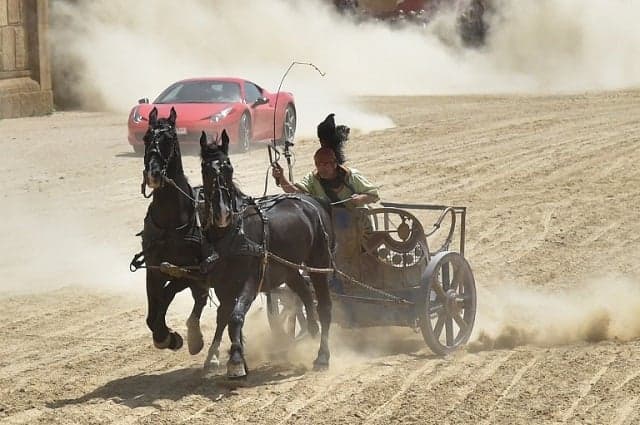 A horse-drawn chariot raced a Ferrari on a dirt track in Rome