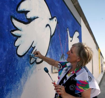 German artist Rosemarie Schinzler recreating “All Open,” one of her two original paintings at East Side Gallery. Photo: DPA