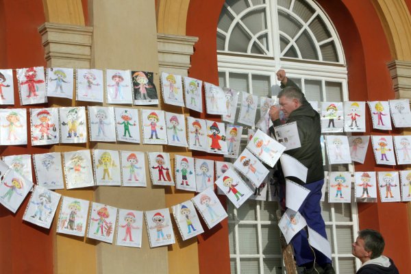 A man hangs up Sandman pictures on the façade of the film museum in Potsdam, near the Sandman's studio at Babelsberg film park. Photo: DPA