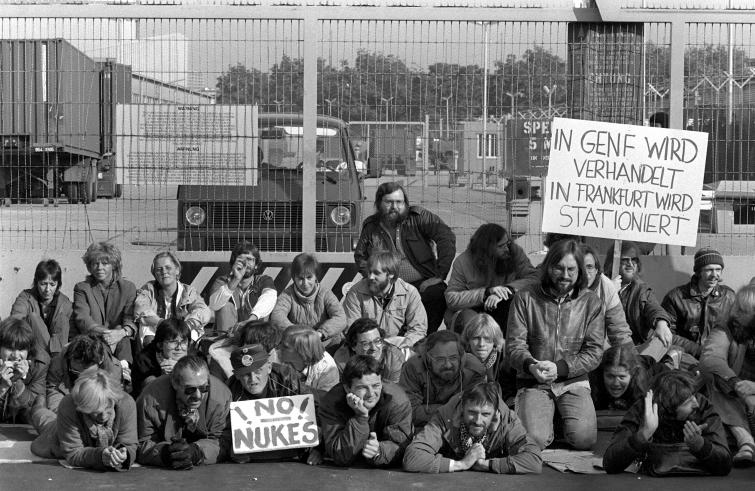 Around 100 members of the Green party, including Joschka Fischer (right next to the sign “No Nukes”) block US-military property in Frankfurt district Hausen on 24-10-1983. According to their sources, this area was designated for mount of Pershing II missiles.  At first the Hessian Greens held raging street marches against nuclear power plants, atomic missiles and the West airstrip.  Since then, the party has distinguished itself with solid work in parliament.  Photo: DPA