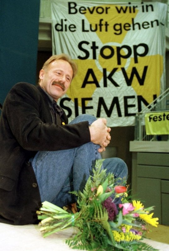 The Greens have long opposed atomic energy.  Sitting on the edge of the stage, Jürgen Trittin listens to the speeches at the Greens convention in Magdeburg in 1998.  In the background is a banner protesting nuclear energy.Photo: DPA