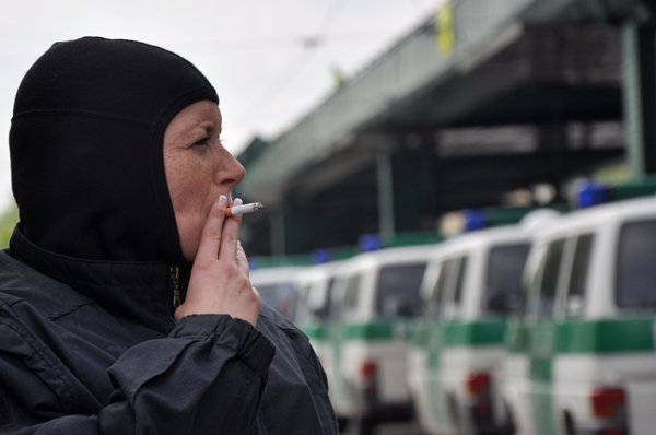 A policewoman removed her mask and helmet for a cigarette break.Photo: Julia Lipkins