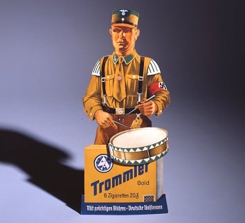 A piece of advertising which ran from 1933 to 1945. It shows a member of the <i>Sturmabteilung</i>, or <i>SA</i>, the paramilitary wing of the Nazi party. Photo: Indra Desnica/Deutsches Historisches Museum