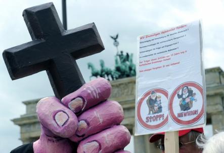 But still they came, with crucifixes and signs of derision. Photo: DPA