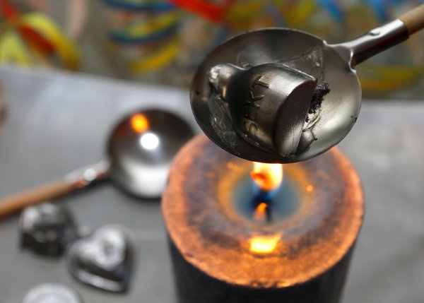 Melting lead on New Year's Eve to tell the future<br>After the New Year has been welcomed with a toast, party-goers in Germany often gather round to melt lead over candles. The molten metal is then poured into a basin of cool water, and hardens into a shape. The shape of this lead nugget is supposed to predict the year ahead.Photo: DPA