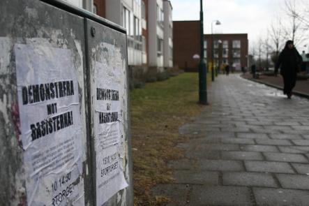 Rosengård scene<br>Lady walks past old poster protesting against racismPhoto: Patrick Reilly