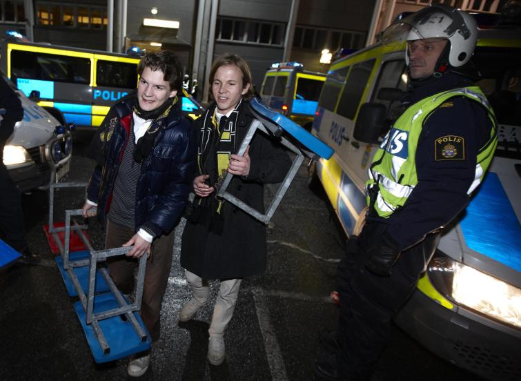 Fans walk by police with newly acquired chairs from Råsunda StadiumPhoto: Fredrik Persson/Scanpix (File)