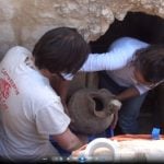 Archaeologists remove a vase found in the tomb.Photo: University of Turin