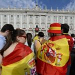 People drapped in a Spanish flags wait outside the Royal Palace in Madrid. Photo: Gerard Julien/AFP