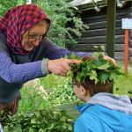 A woman in traditional dress places a Midsummer crown on a child's head.Photo: The Local/Solveig Rundquist