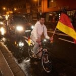 In Koblenz, a fan on a bicycle joins a motorcade to celebrate the German victory.Photo: DPA