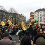 A man dressed as St. Patrick, who was known to have driven the snakes from Ireland, leads a group of people propping up a golden serpent. Photo: Emma Anderson, The Local