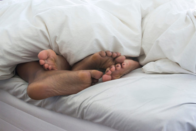 two people in bed, only their feet are showing under the covers