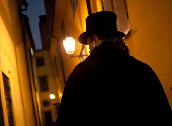 a man walking through a spooky looking Old Town in Stockholm