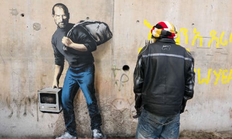 UK street artist Banksy paints at Calais camp