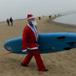 Surf’s up: Dozens of Santas take to the waves in Barcelona