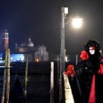 A costumed reveller poses in front of gondolas at St Mark's square (Piazza San Marco) during the Venice Carnival on January 30th, 2016 in Venice.Photo: AFP