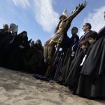 Penitents from the "Cristo Salvador" brotherhood stand around an effigy of Jesus Christ during a Holy Week procession on the beach in ValenciaPhoto: Jose Jordan/AFP