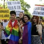 People hold signs, including one reading, "out of the closet all year long". Photo: Javier Soriano/AFP