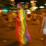 A man draped in a rainbow flag during Madrid Pride 2016. Photo: Sara Houlison 