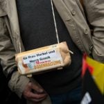 A demonstrator has an egg-box tied around his neck, with the message: "For Mrs. Merkel and Mr. Gauck [the German President] ten fresh free-range eggs"Photo: DPA