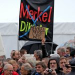 The celebrations were also marked by demonstrations by the anti-Islam Pegida movement. Here, protesters hold up banners reading "Merkel has to go" and "Merkel Dictatorship", which has been crossed out.Photo: DPA