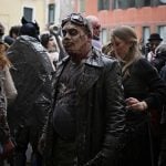 People dressed as zombies wander the streets before the opening ceremony.Photo: Marco Bertorello/AFP