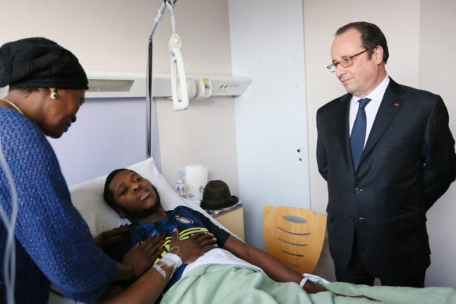 French president visits man 'raped with police baton' as suburban tensions simmer