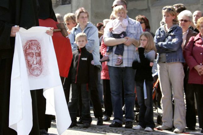 Mourners dressed in black carry a portrait of Jesus Christ during the traditional Good Friday celebration 06 April 2007 in Romont. Photo: FABRICE COFFRINI / AFP