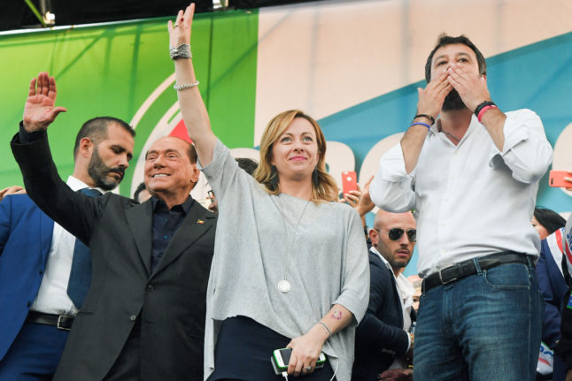 Salvini (R) on stage with Meloni and coalition partner Berlusconi at a joint rally October 19, 2019 in Rome.