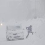 A man struggles to clear snow near a car.Photo: Mats Andersson / TT