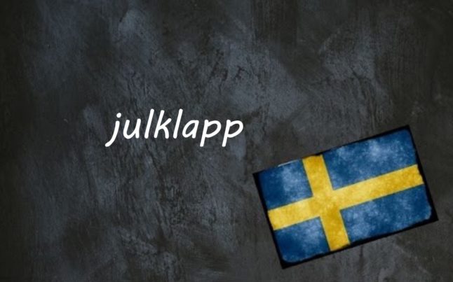 the word julklapp on a black background by a Swedish flag