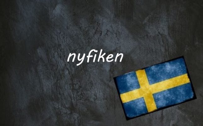 the word nyfiken written on a blackboard next to the swedish flag