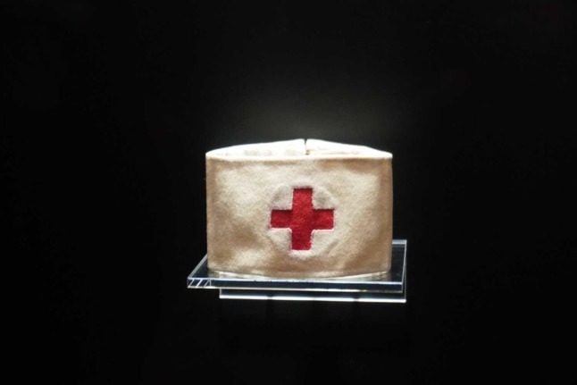A close up of a Red Cross armband, which looks like an inverse of the Swiss flag