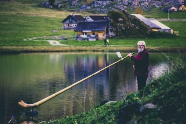 A man with an unusually large pipe on a lake in Switzerland. Image: Pexels. 