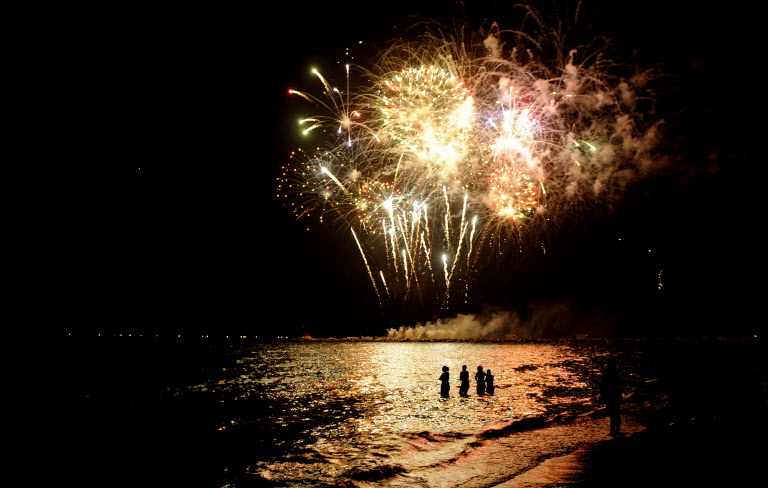 Revellers in the sea enjoy the Sant Joan fireworks display in Catalonia. 