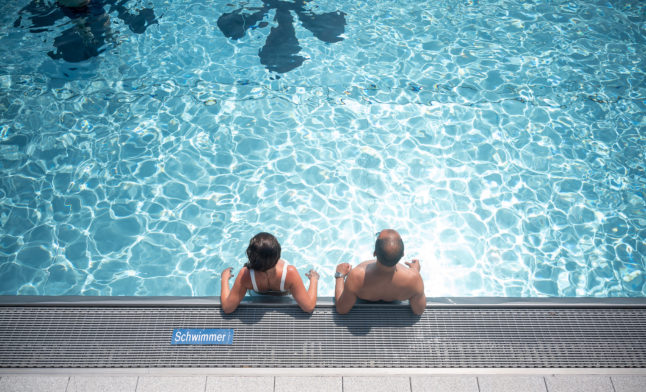 Two people sit in a pool in Wiesbaden, Hesse in June 2021.