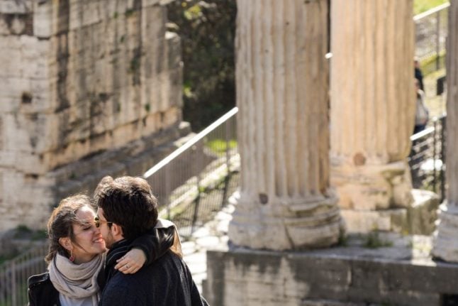 A couple exchanges a kiss at the forum in Rome. 