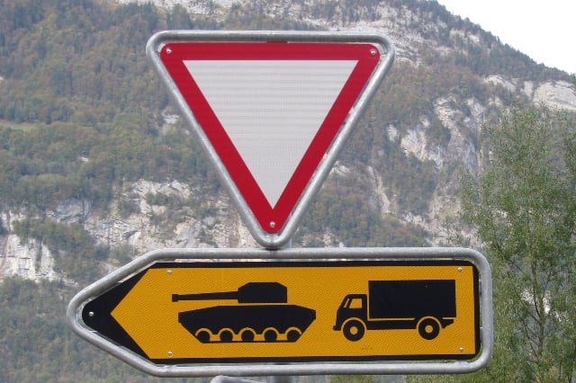A road sign tells military vehicles what they need to do