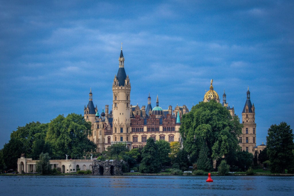 Schwerin Castle on Lake Schwerin can be seen under a dark blanket of clouds. 